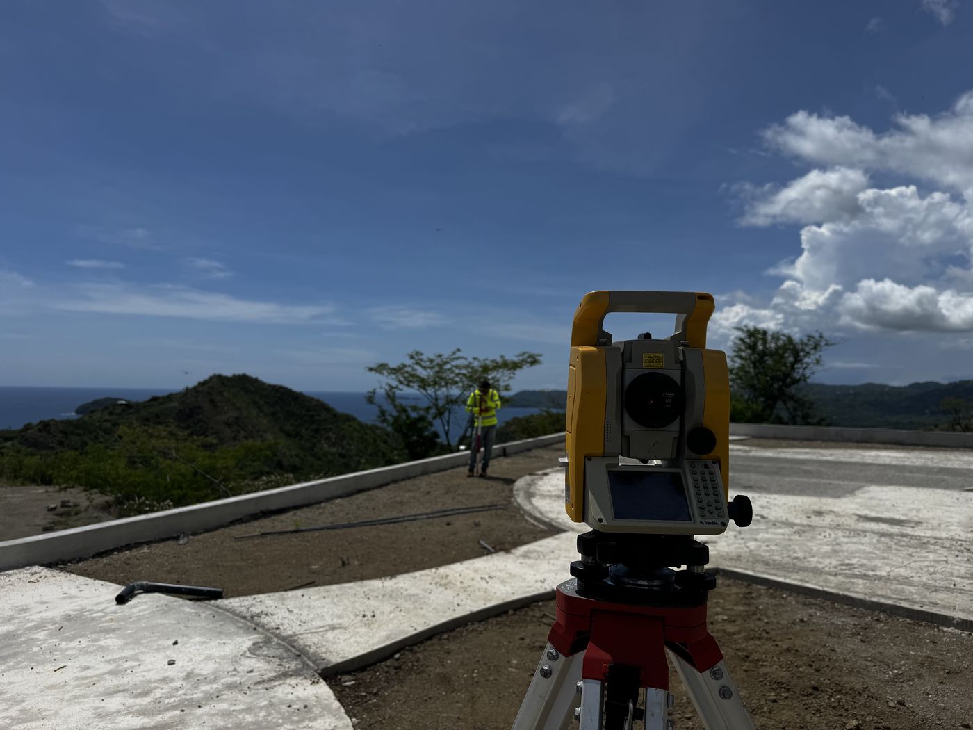 Total station on site with coastal hills in the distance